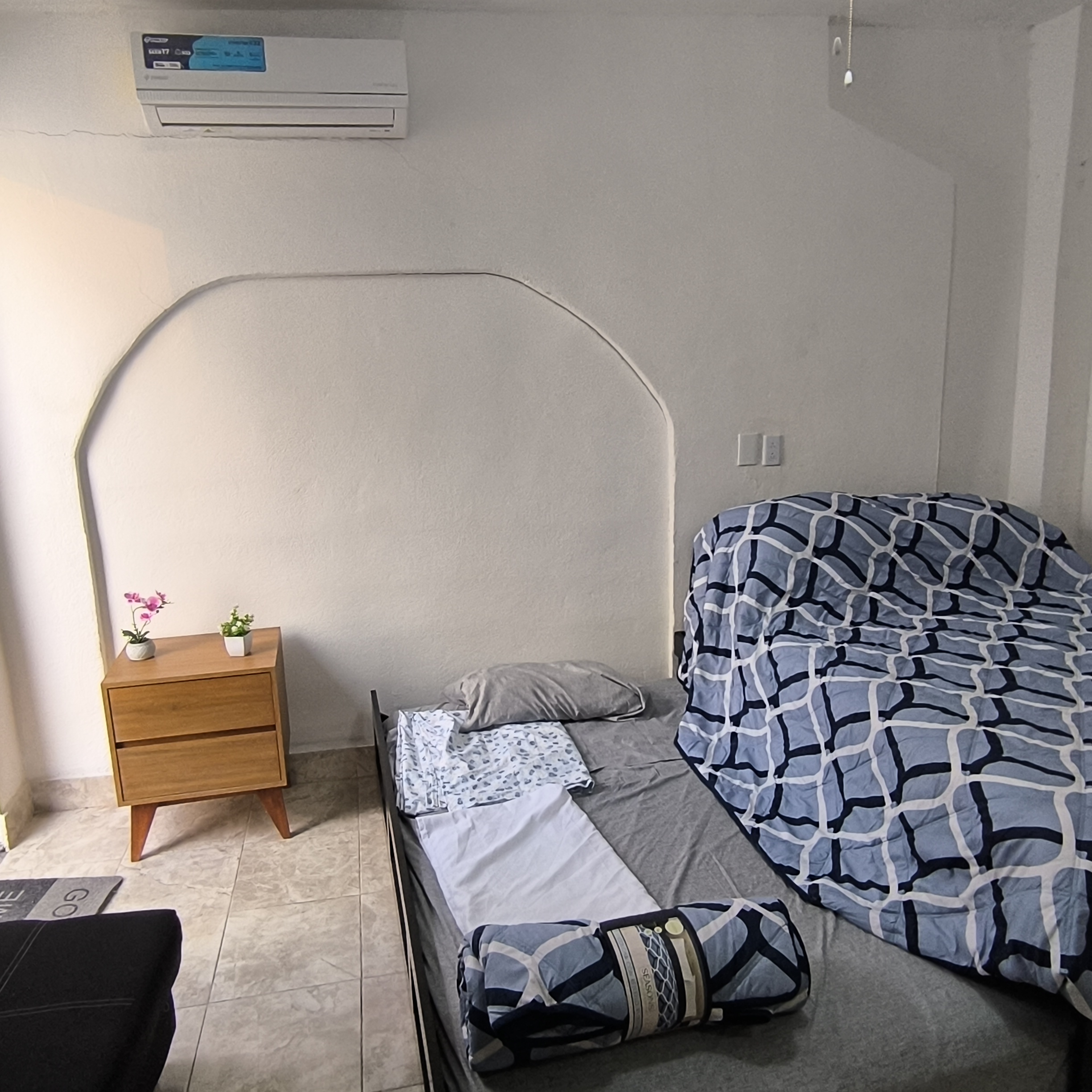 El Loft donde se ve la cama, la cangurera, el buró y el aire acondicionado