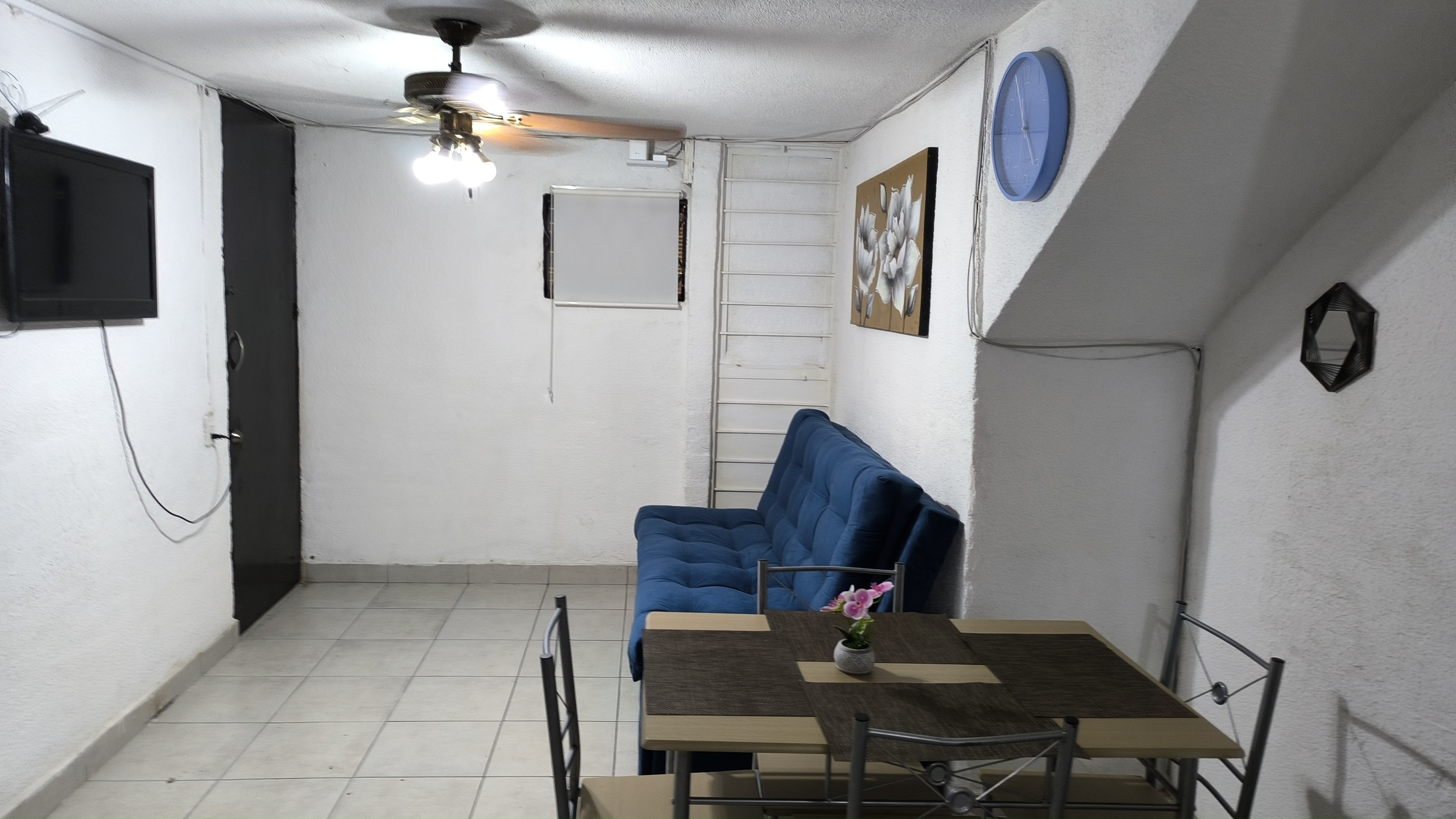 El Loft donde se ve el comedor, el sillón, el cuadro y la tele