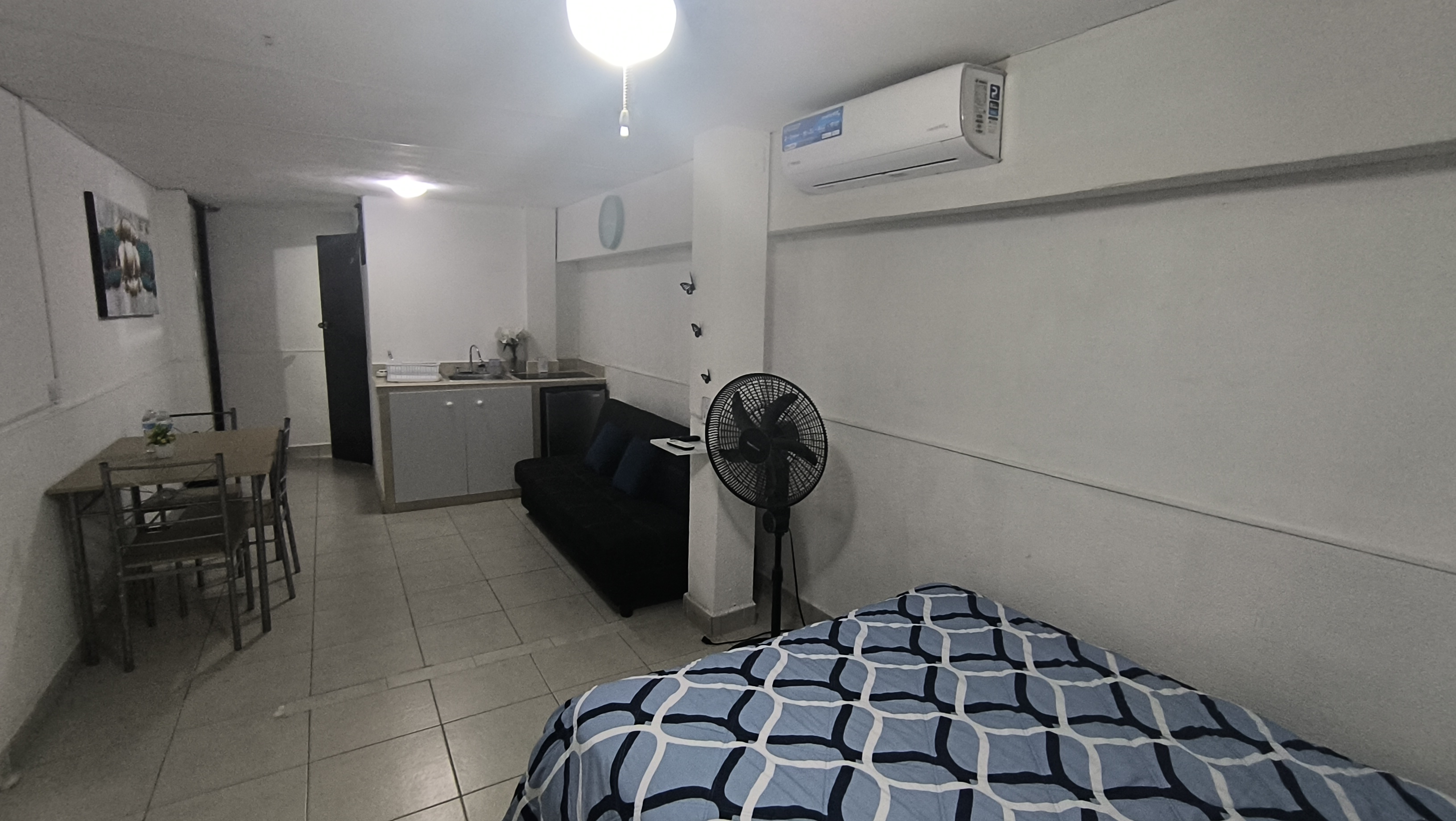 El cuarto 3 del Loft donde se ve el sillón, el ventilador, el comedor el aire acondicionado y la cocineta